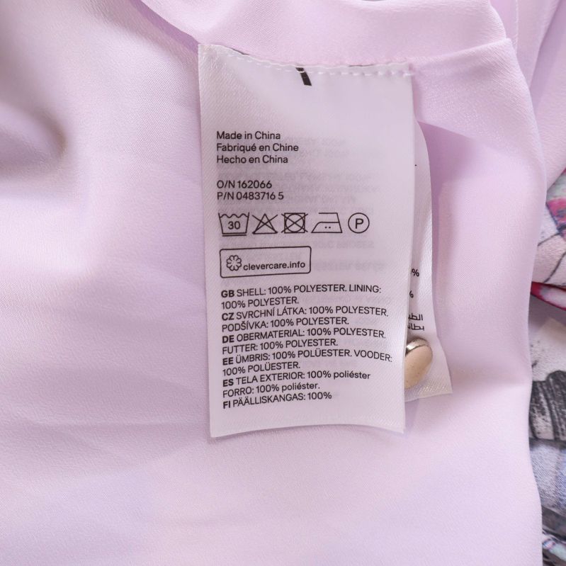 Material- och tvättrådsetikett med information om polyester och elastan