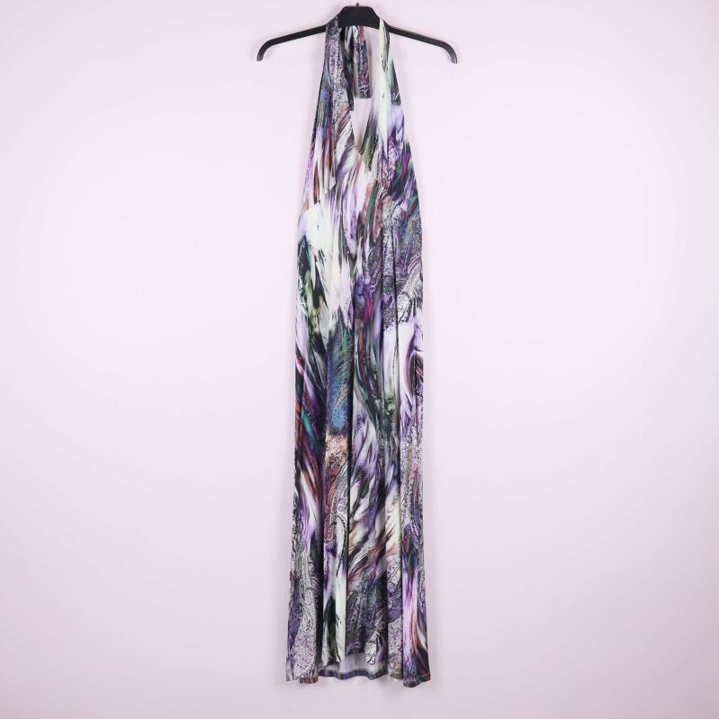 Lång klänning med abstrakt flerfärgat mönster upphängd mot ljus bakgrund