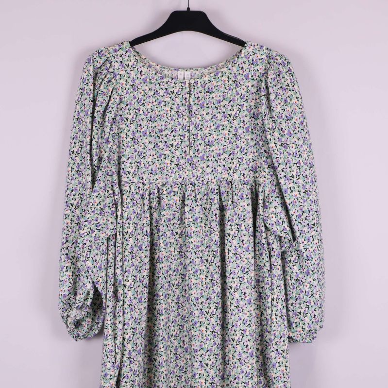 Övre del av klänningen med blommigt mönster och rund hals