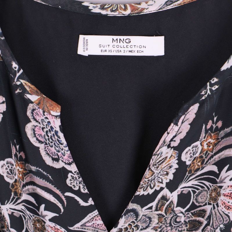 Närbild av V-ringning på blommig klänning