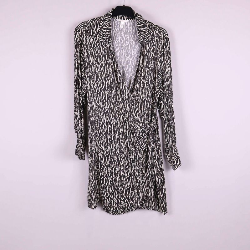 Kort omlottklänning med svartvitt grafiskt mönster och lång ärm