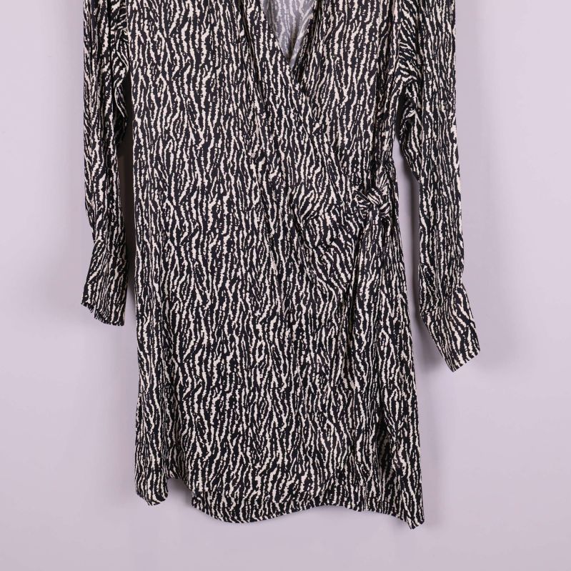 Närbild på nederdelen av omlottklänningen med svartvitt mönster