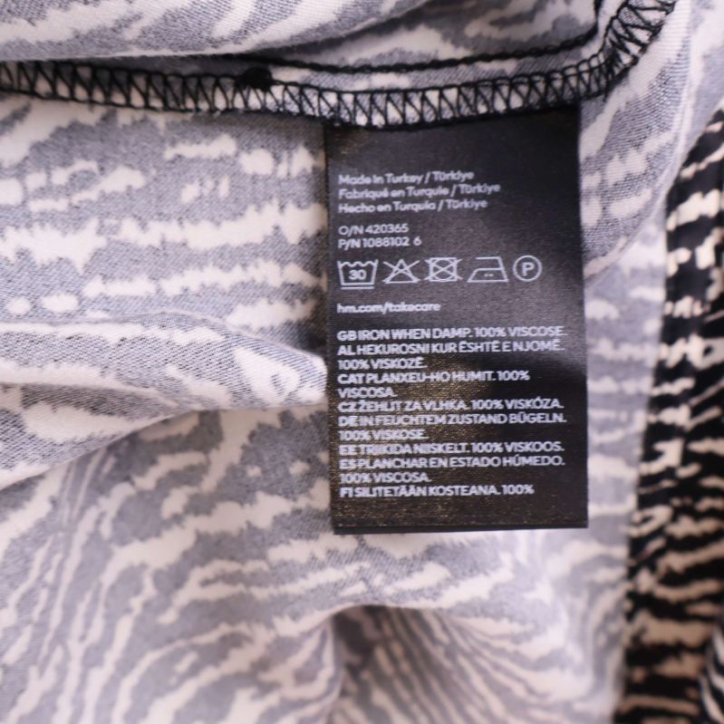 Materialetikett som visar 100% viskos på insidan av plagget