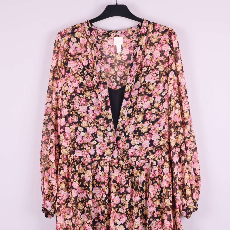 Närbild av klänningens blommiga mönster vid axlarna