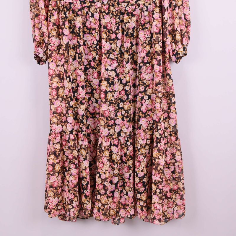 Blommiga detaljer på nedre delen av klänningen