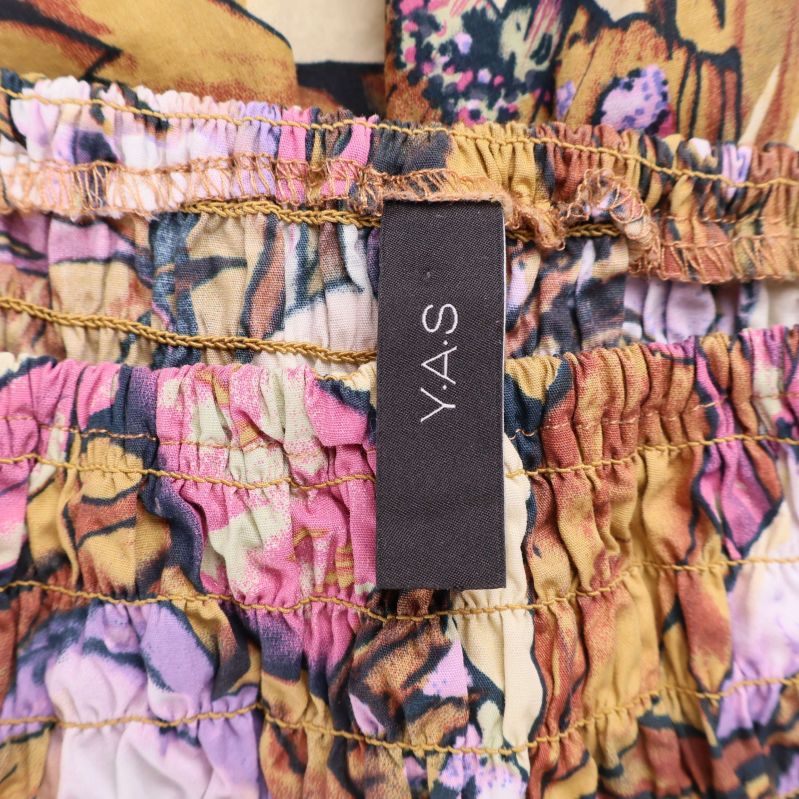 Närbild på Y.A.S-logga i klänningens linning