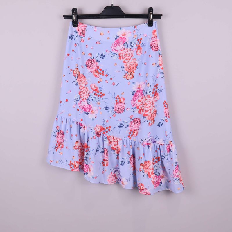 Blommig kjol i ljusblått med volang framtill