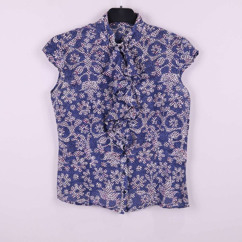 Blommig kortärmad blus med volang framtill upphängd på galge