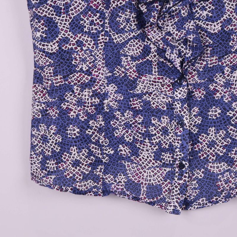 Nederdel av blommig blus med tydligt blåvitt mönster och volang