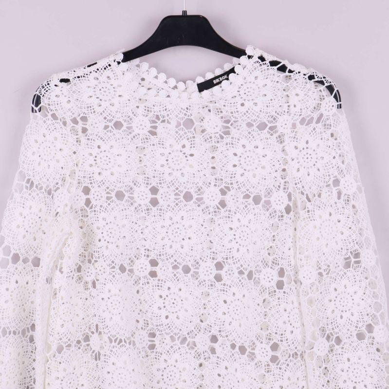 Närbild på blusens nederkant med fin spetskant