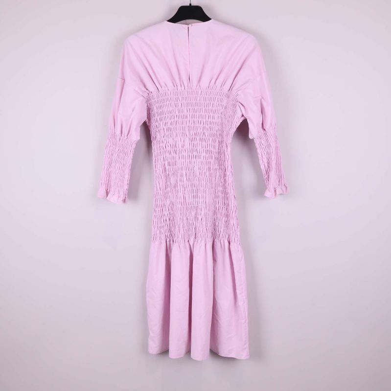 Ljusrosa klänning med smock bakifrån på galge