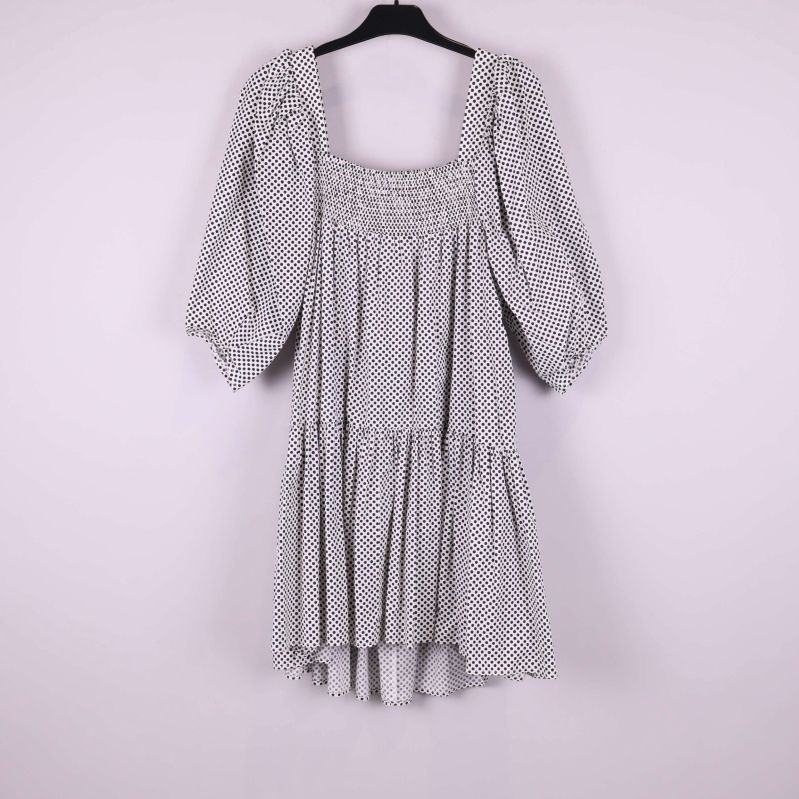 Prickig klänning med puffärm hängande mot ljus bakgrund