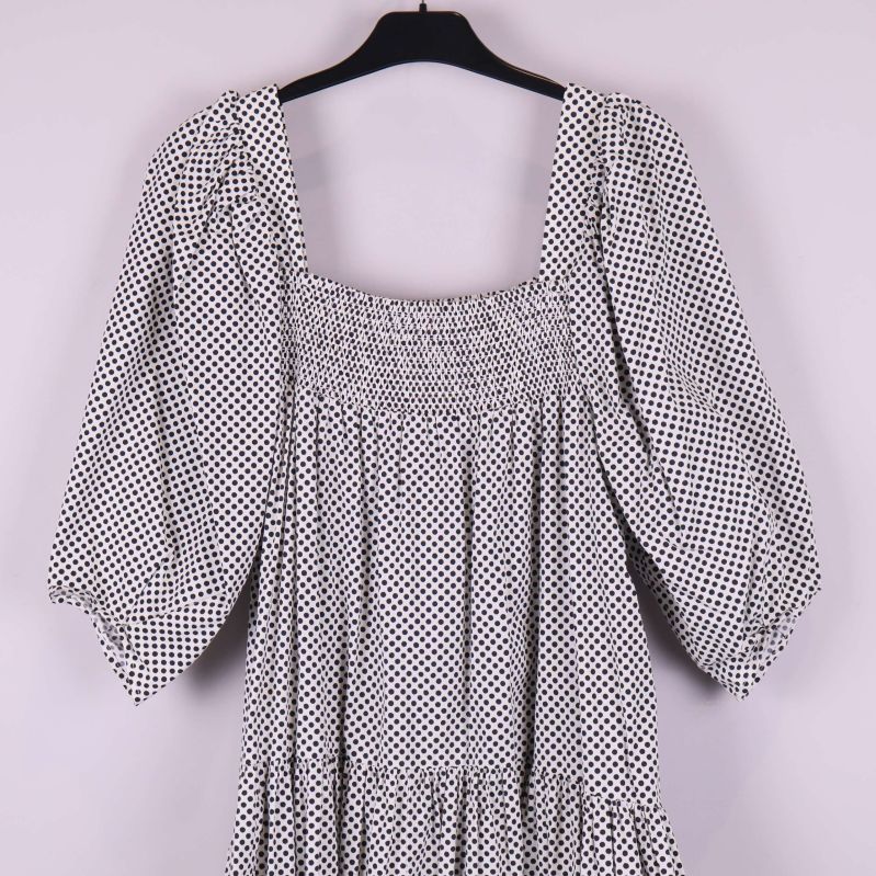 Övre delen av klänning med smock och puffärm i prickigt tyg