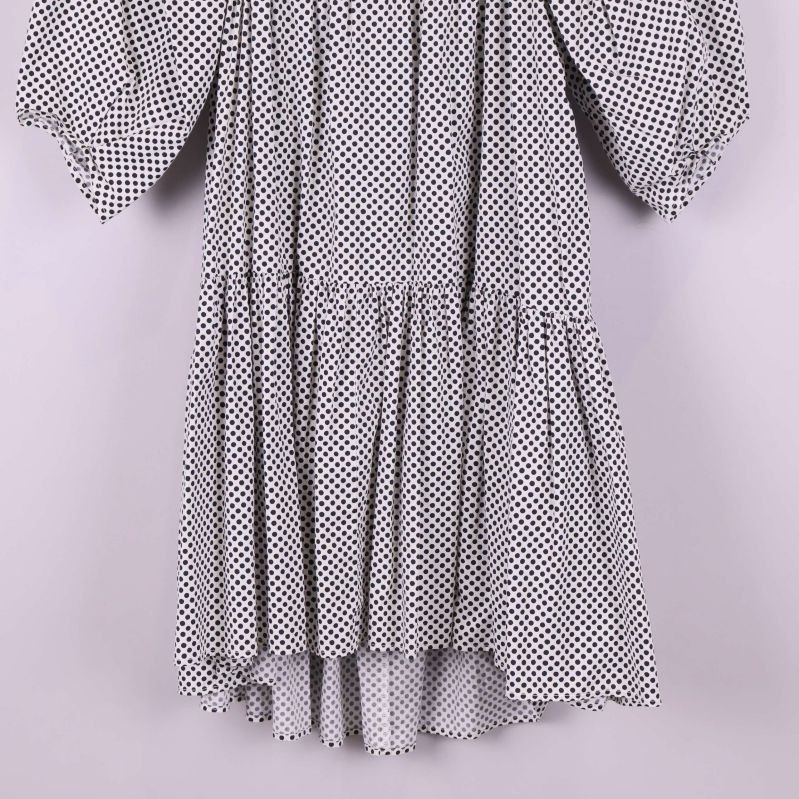 Nederdelen av en prickig klänning med volangkant