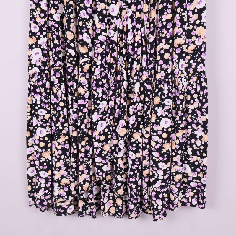 Nederdel av svart blommig plisserad midikjol