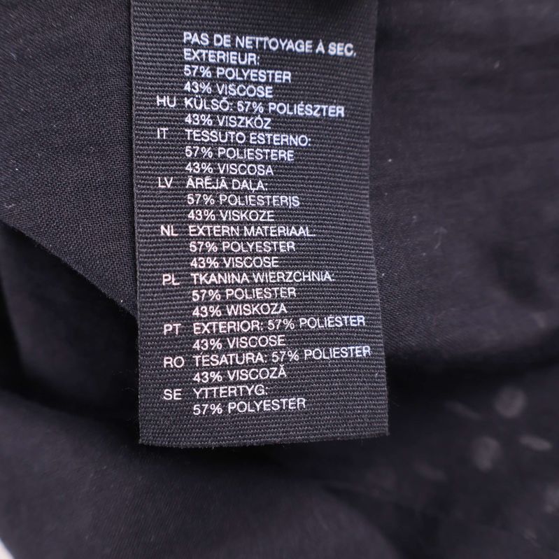 Materialetikett visar 57% polyester och 43% viskos