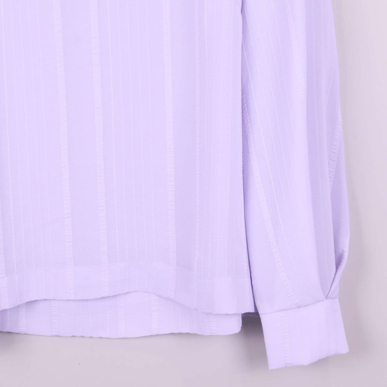 Ärmslut och nederkant på ljuslila blus med bred manschett