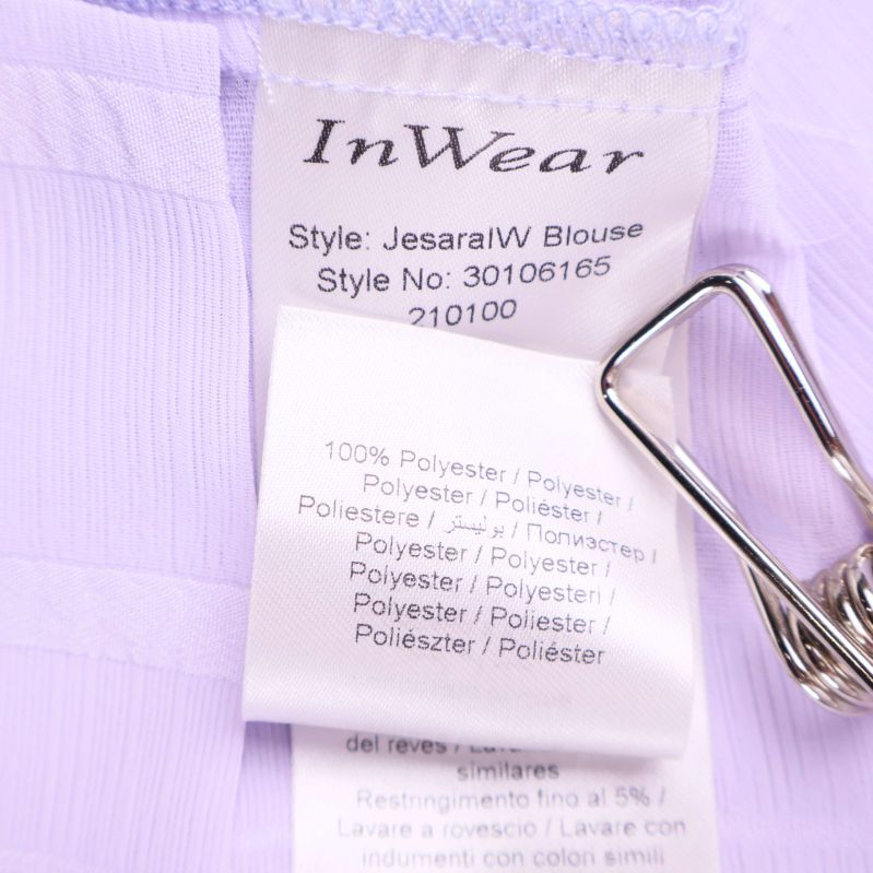 Materialetikett 100% polyester på ljuslila blus