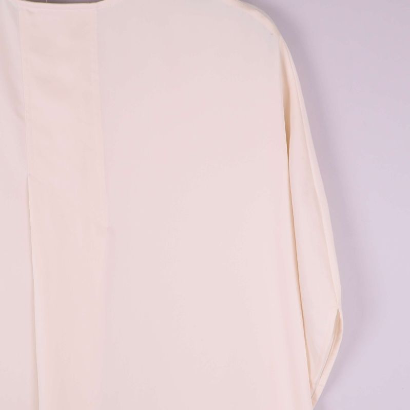 Närbild av bakre axelsöm på ljus kaftan