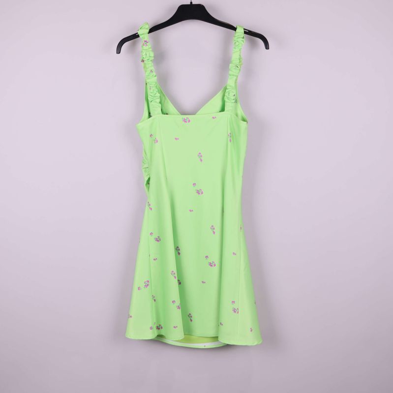 Baksidan av ljusgrön klänning med lila blommor och rynkade axelband