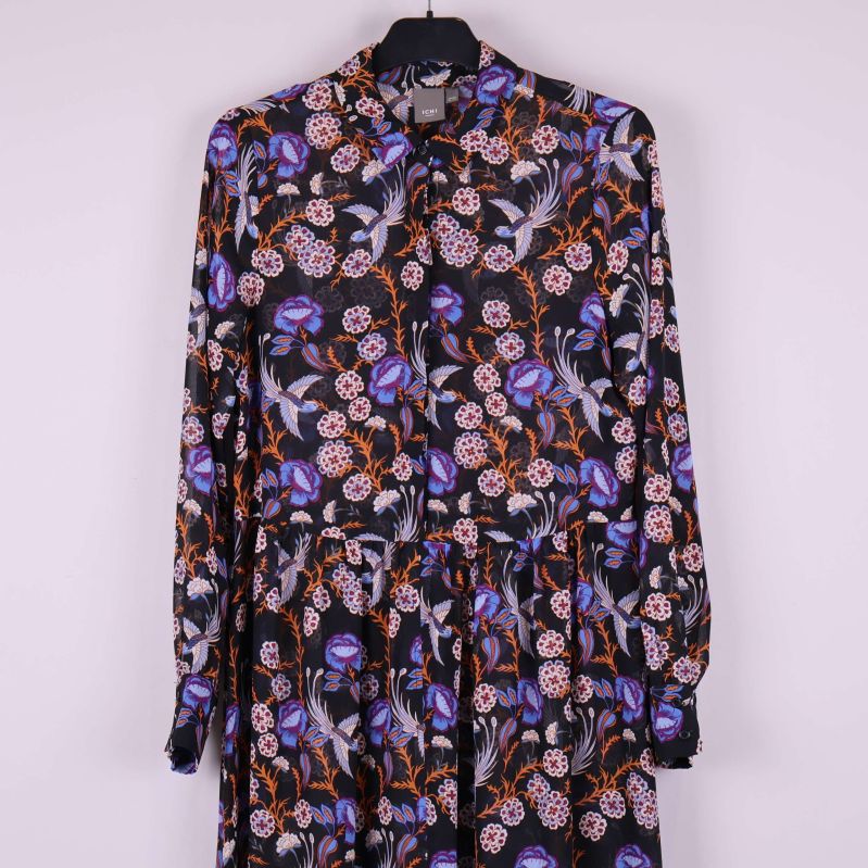 Detaljer av överdelen och långa ärmar på klänning