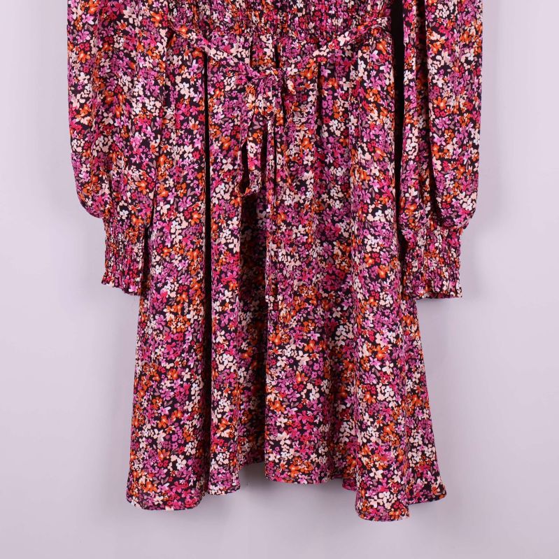 Detaljbild på klänningens kjol och knytband