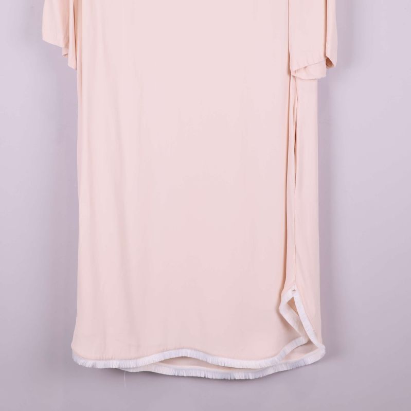 Närbild på fransdetaljer vid klänningens nederkant