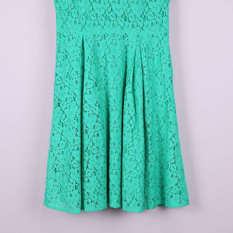 Detalj av kjolens nedre del med veck och spetsmönster