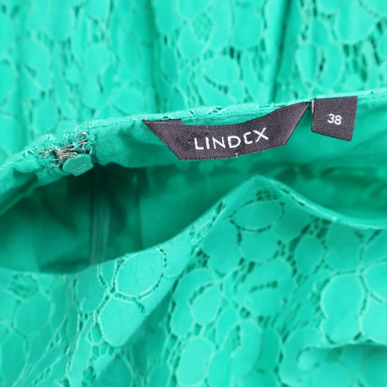Närbild på Lindex-etikett och storleksmärkning 38 på klänning