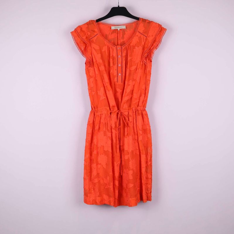 Kort orange klänning med strukturmönster hänger på galge