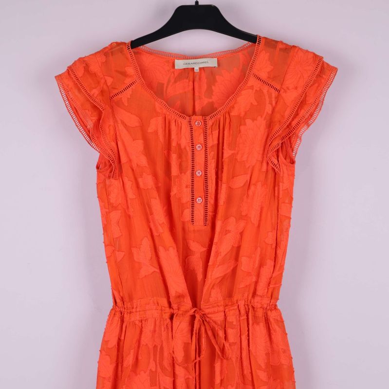 Övre del av orange klänning med knappslå framtill