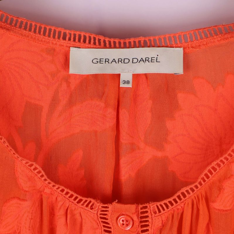 Närbild på etikett från Gerard Darel i orange klänning