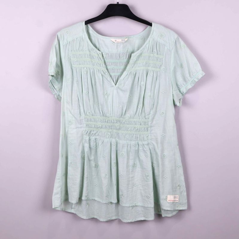 Ljusgrön blus med broderade detaljer och v-ringning på galge