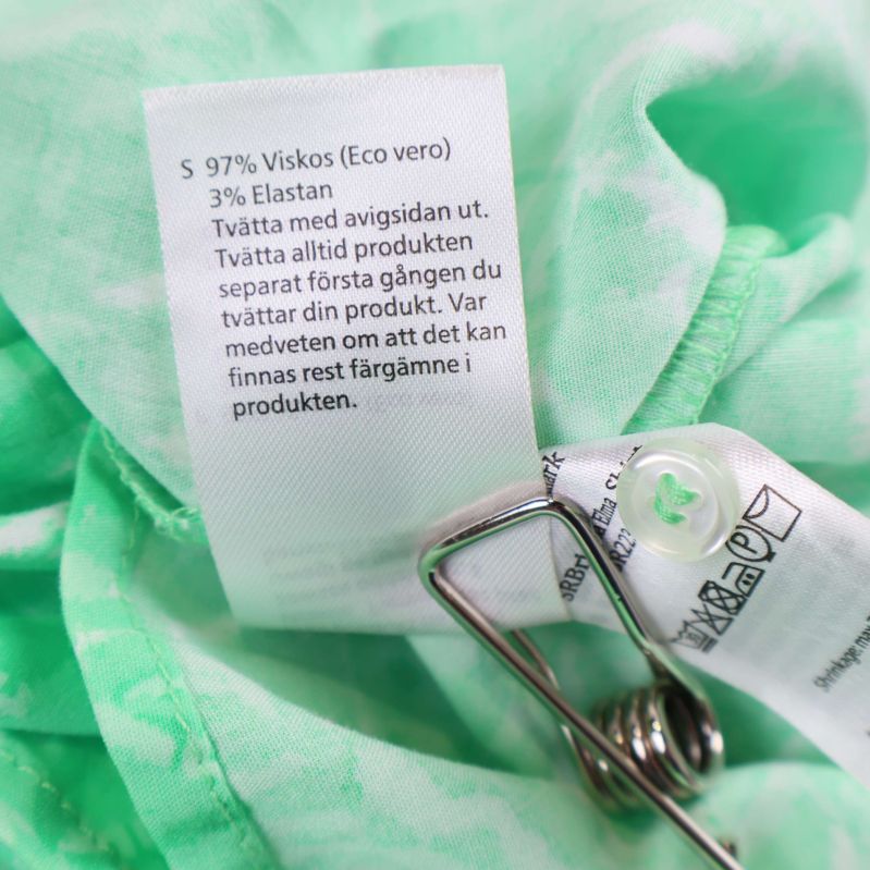 Tvättrådslapp med materialinformation på svensk text