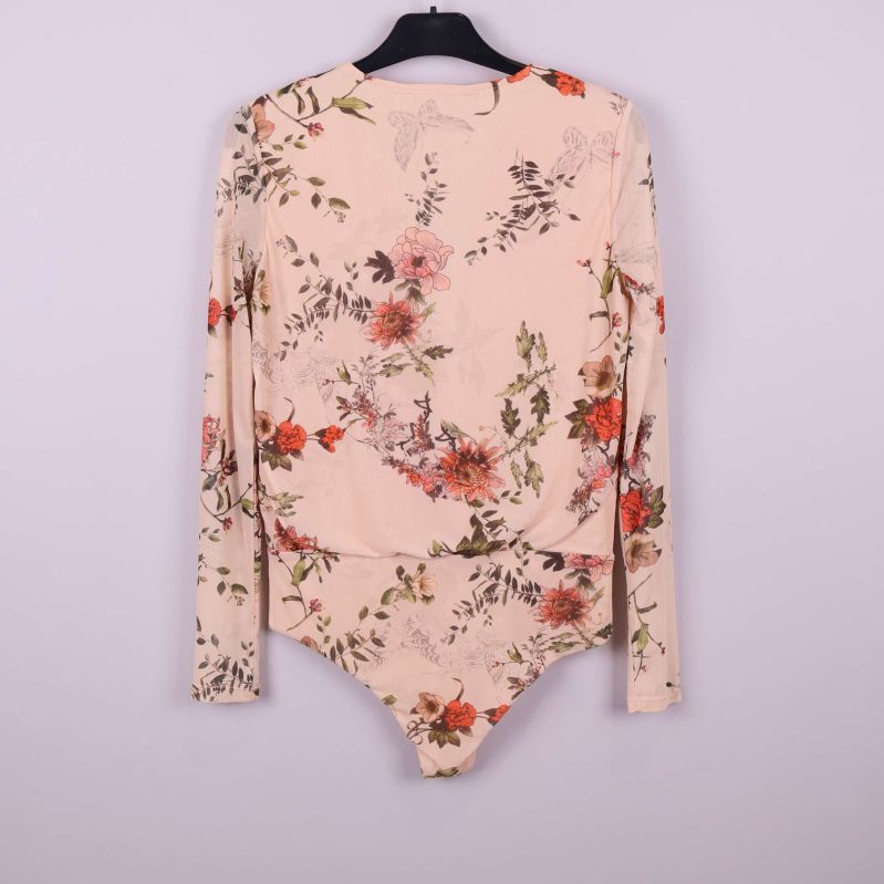 Baksidan av blommig beige body med ärm