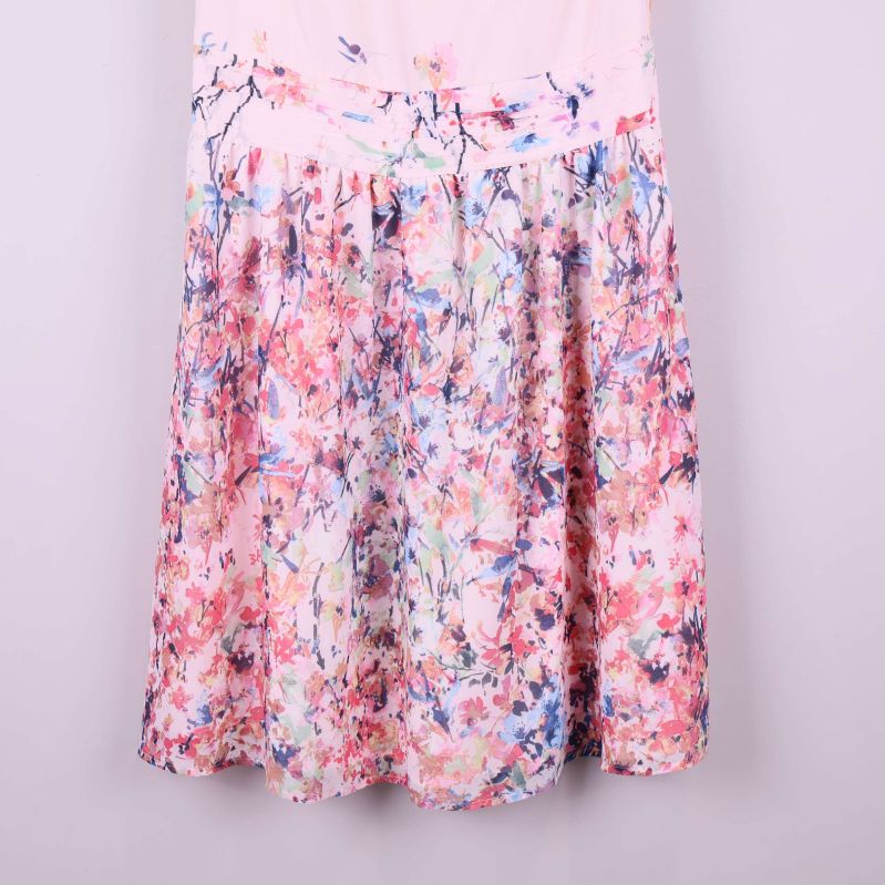 Närbild på klänningens blommiga kjoldel i rosa toner