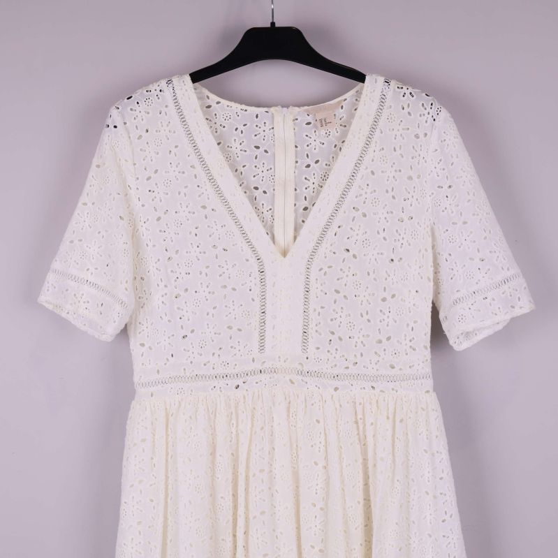 Närbild på broderad V-ringning och ärmar framtill