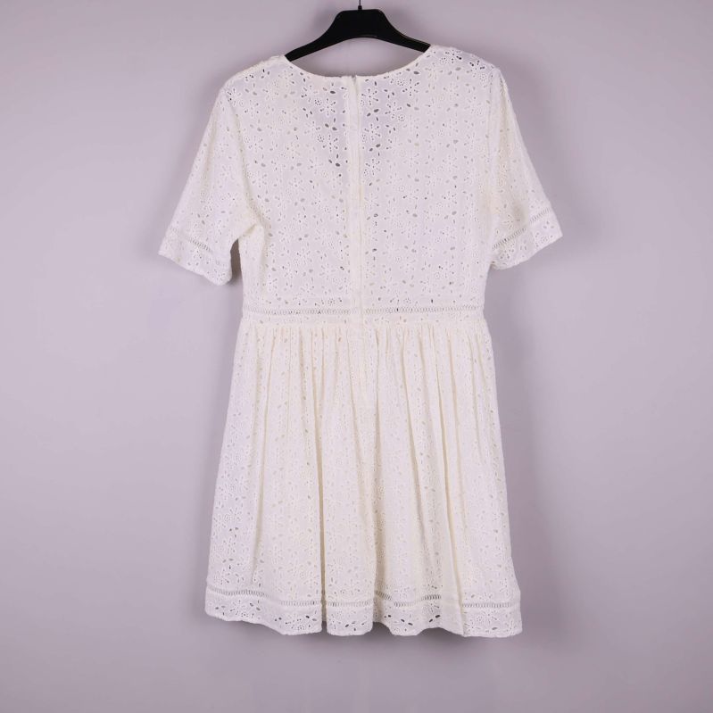 Klänning bakifrån visar dold dragkedja och broderade mönster i tyget