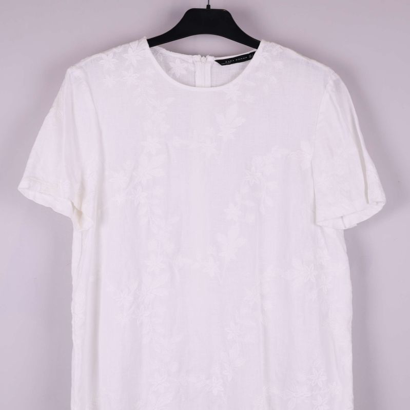 Detaljbild på klänningens framsida och ärm