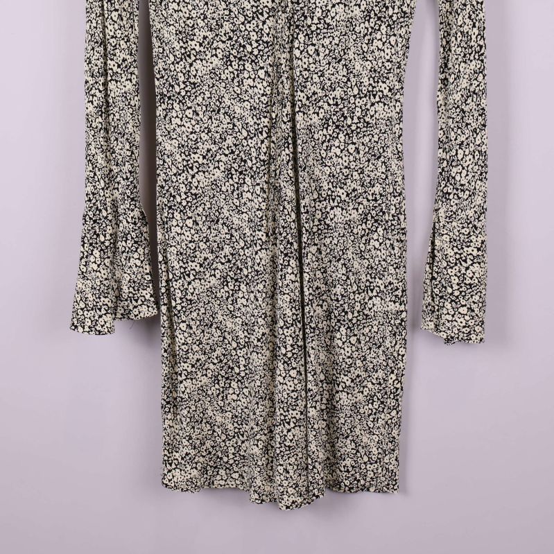 Nedre del av blommönstrad klänning i beige och svart