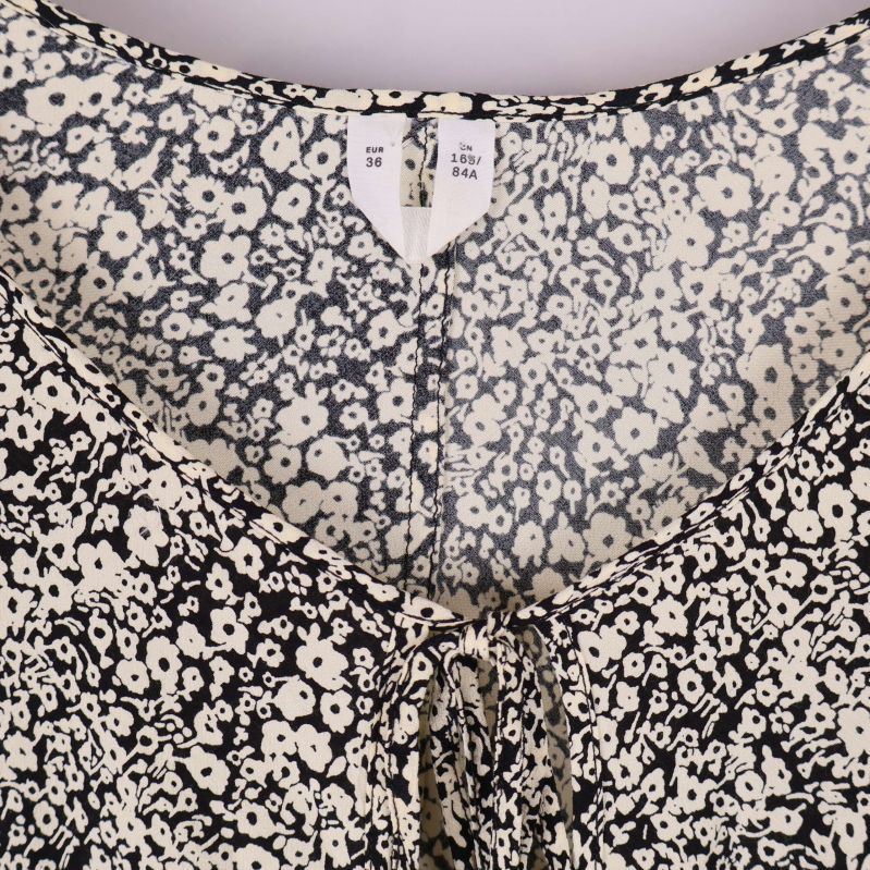 Närbild på blommönstrad klänning och storleksetikett