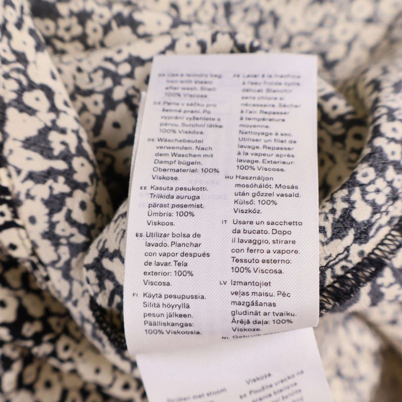 Materiallapp visar 100% viskos på blommig klänning