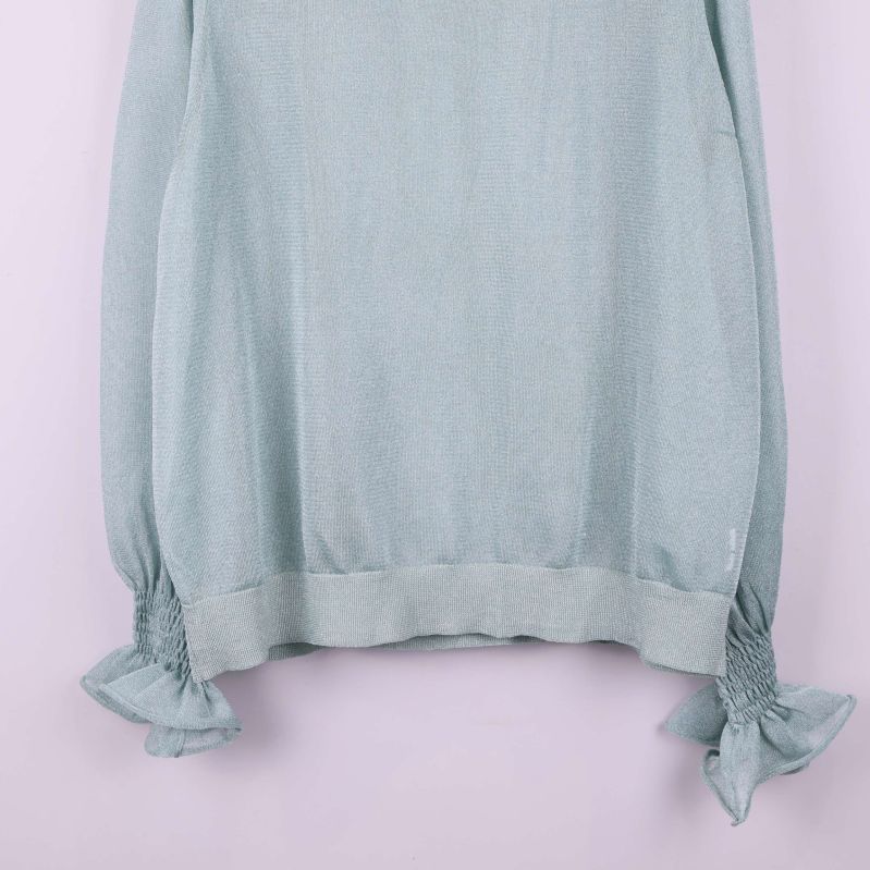 Närbild på volangdetaljer vid ärmsluten