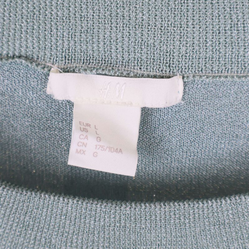 Närbild på storleksetikett från H&M i tröjans hals