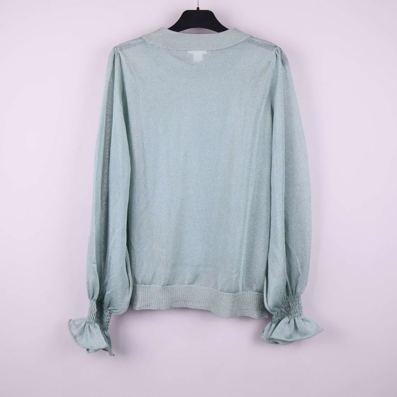 Ljusgrön tröja bakifrån med volangdetaljer vid ärmslut