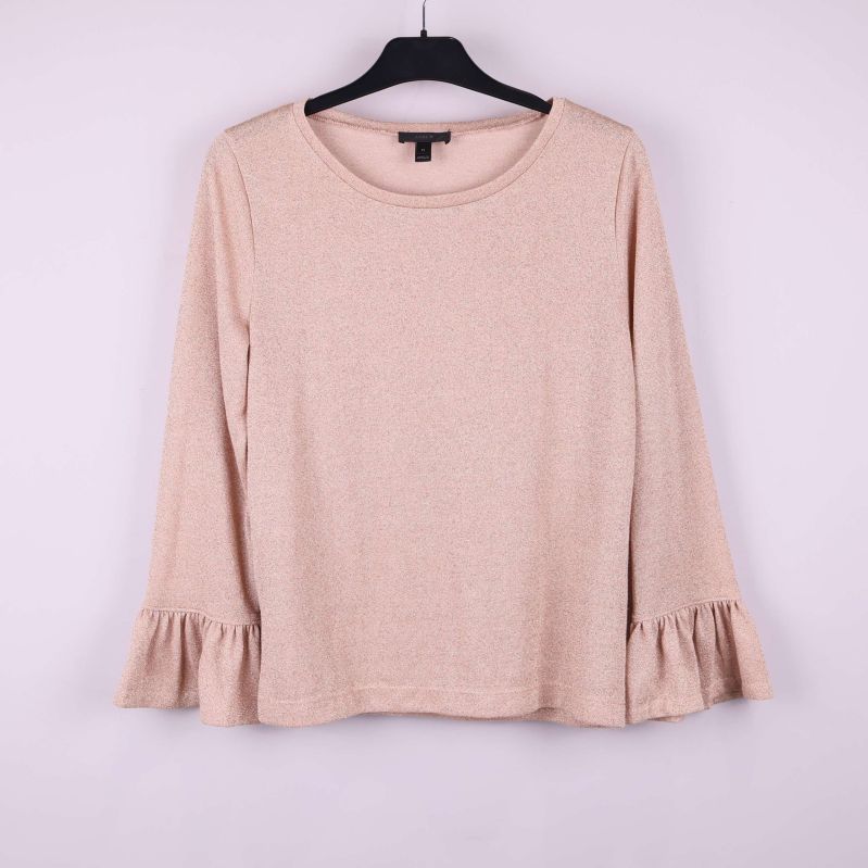 Beige tröja med volangärm och rund hals hänger på galge