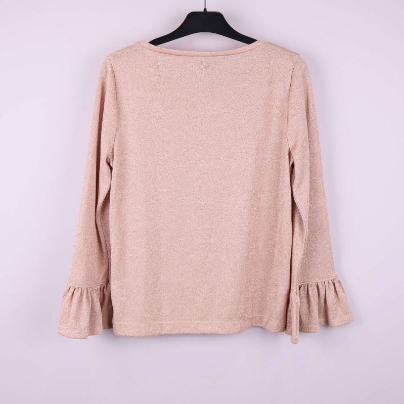 Baksida av beige tröja med volang vid ärmslut