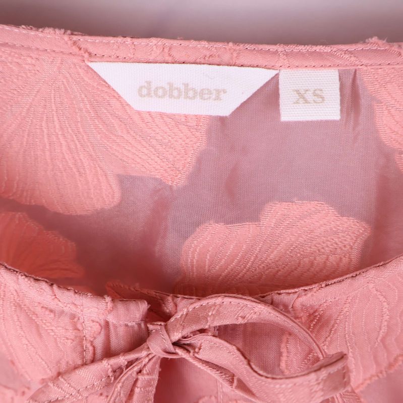 Närbild på dobber-logotyp och storlek XS invändigt
