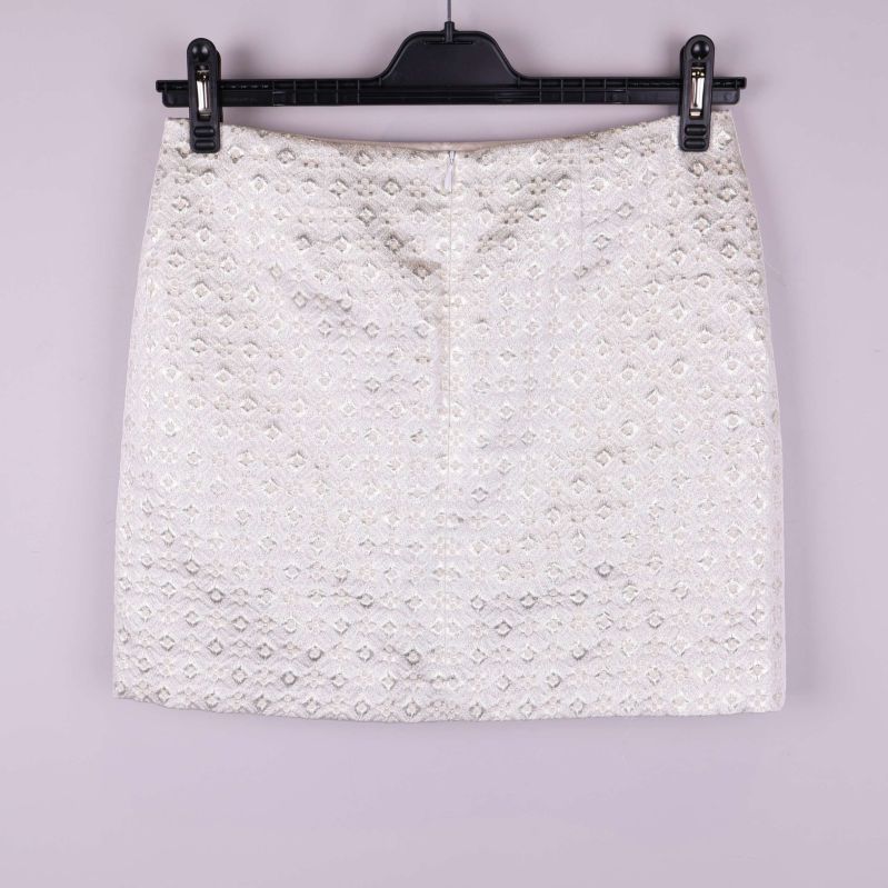 Kort kjol i ljust tyg med strukturmönster bakifrån