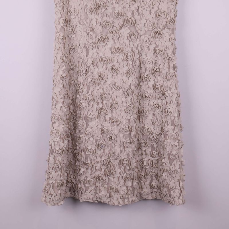 Nederdelen av klänningen med strukturerade blommor i fokus